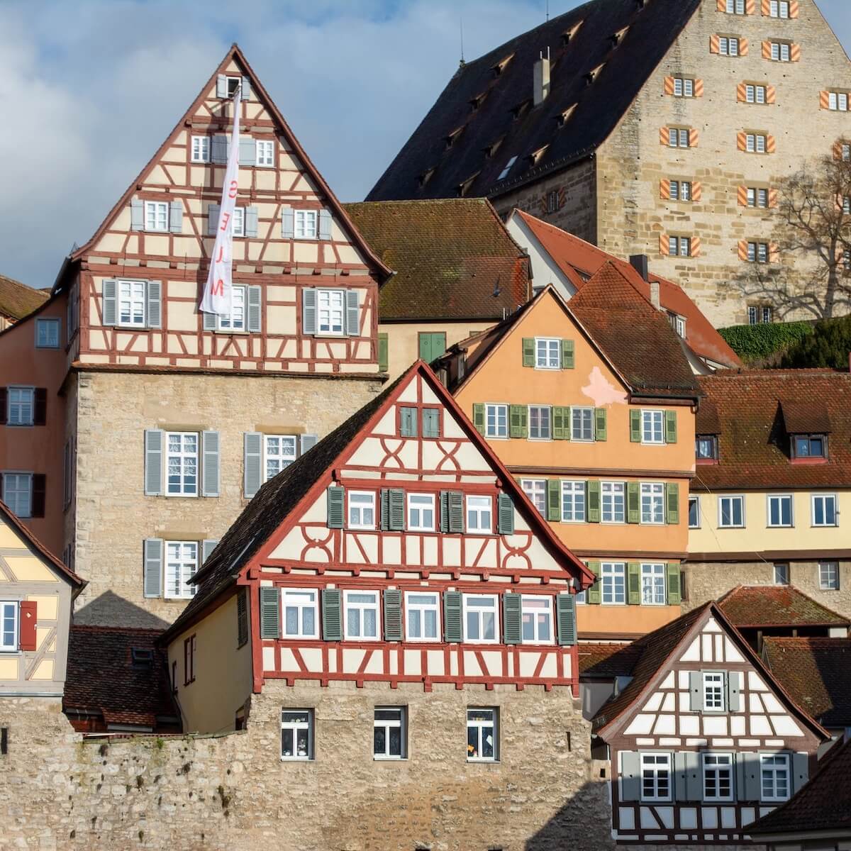 Home 3 Reihen traditioneller deutscher Fachwerkhäuser mit roten und weißen Holzrahmen säumen die charmanten Straßen von Schwäbisch Hall; bunte Fassaden, Fensterläden und ein großes mittelalterliches Bauwerk schaffen eine eindrucksvolle Kulisse für die alte Welt.